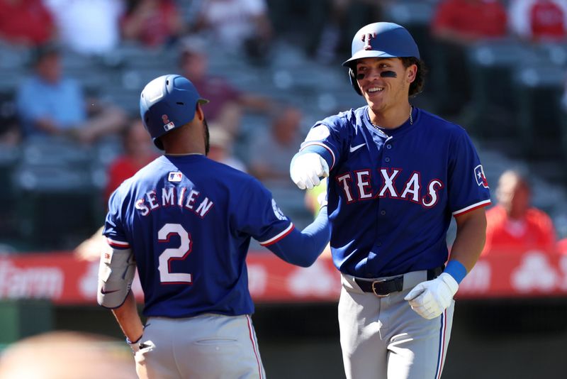 Sep 29, 2024; Anaheim, California, USA;  Texas Rangers designated hitter Dustin Harris (38) celebrates with second baseman Marcus Semien (2) after hitting a home run, his first MLB home run, during the ninth inning against the Los Angeles Angels at Angel Stadium. Mandatory Credit: Kiyoshi Mio-Imagn Images