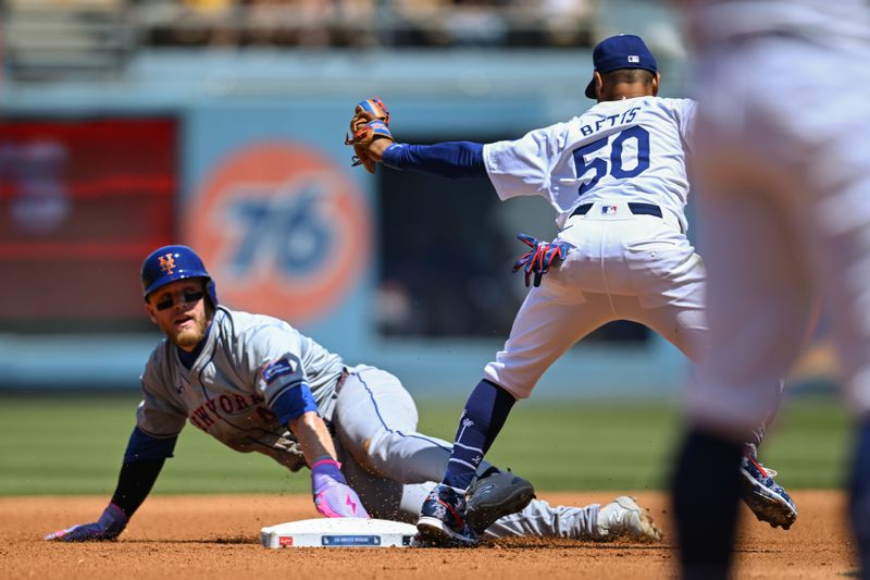 Apr 21, 2024; Los Angeles, California, USA; Los Angeles Dodgers shortstop Mookie Betts (50) at second base against New York Mets outfielder Harrison Bader (44) during the third inning at Dodger Stadium. Mandatory Credit: Jonathan Hui-USA TODAY Sports