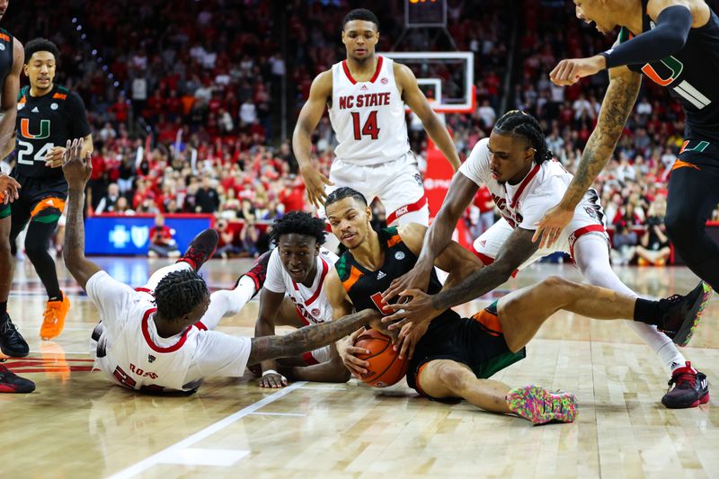 Jan 14, 2023; Raleigh, North Carolina, USA; Miami Hurricanes guard Isaiah Wong (2) holds onto the ball while North Carolina State Wolfpack guard Casey Morsell (14),  forward Greg Gantt (23), forward Ernest Ross (24), and  guard Jarkel Joiner (1) all grab for it towards the end of the second half at PNC Arena. Mandatory Credit: Jaylynn Nash-USA TODAY Sports