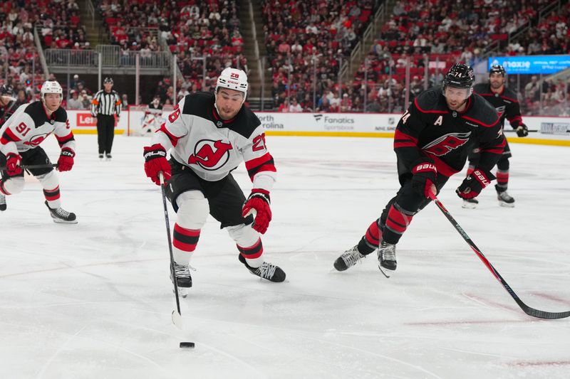 Mar 28, 2026; Raleigh, North Carolina, USA;  New Jersey Devils right wing Timo Meier (28) skates with the puck outside Carolina Hurricanes defenseman Jaccob Slavin (74) during the second period at Lenovo Center. Mandatory Credit: James Guillory-Imagn Images