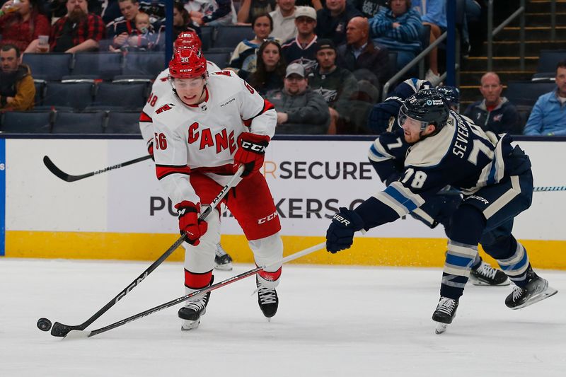 Apr 16, 2024; Columbus, Ohio, USA; Columbus Blue Jackets defenseman Damon Severson (78) sticks the puck away from Carolina Hurricanes defenseman Scott Morrow (56) during the third period at Nationwide Arena. Mandatory Credit: Russell LaBounty-USA TODAY Sports