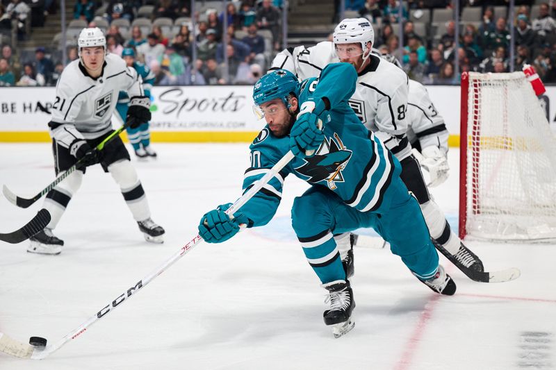 Apr 4, 2024; San Jose, California, USA; San Jose Sharks right wing Justin Bailey (90) plays the puck against Los Angeles Kings defenseman Vladislav Gavrikov (84) and defenseman Jordan Spence (21) during the second period at SAP Center at San Jose. Mandatory Credit: Robert Edwards-USA TODAY Sports