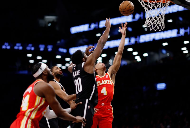 NEW YORK, NEW YORK - MARCH 02: Kobe Bufkin #4 of the Atlanta Hawks goes to the basket as Day'Ron Sharpe #20 of the Brooklyn Nets defends during the second half at Barclays Center on March 02, 2024 in the Brooklyn borough of New York City. The Nets won 114-102. NOTE TO USER: User expressly acknowledges and agrees that, by downloading and or using this photograph, User is consenting to the terms and conditions of the Getty Images License Agreement. (Photo by Sarah Stier/Getty Images)