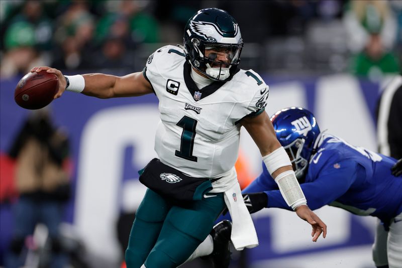 Philadelphia Eagles quarterback Jalen Hurts (1) rolls out of the pocket under pressure against the New York Giants during the first quarter of an NFL football game, Sunday, Jan. 7, 2024, in East Rutherford, N.J. (AP Photo/Adam Hunger)