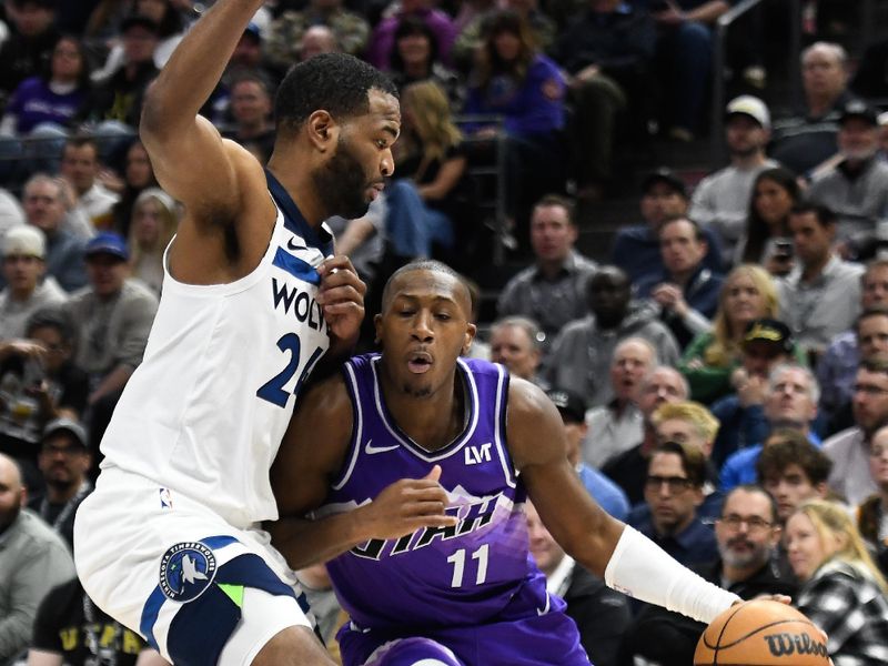 SALT LAKE CITY, UTAH - MARCH 18: Kris Dunn #11 of the Utah Jazz drives into TJ Warren #24 of the Minnesota Timberwolves during the second half of a game at Delta Center on March 18, 2024 in Salt Lake City, Utah. NOTE TO USER: User expressly acknowledges and agrees that, by downloading and or using this photograph, User is consenting to the terms and conditions of the Getty Images License Agreement.  (Photo by Alex Goodlett/Getty Images)