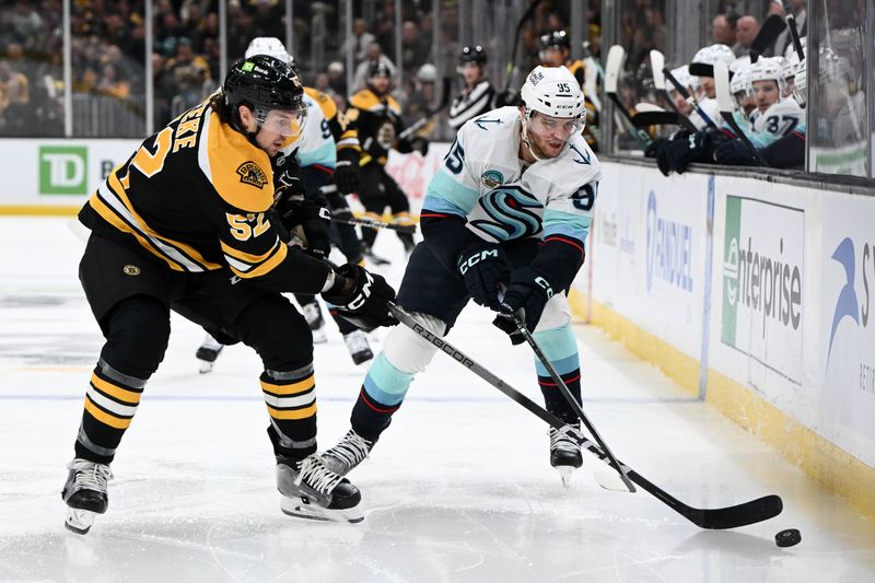Nov 3, 2024; Boston, Massachusetts, USA; Seattle Kraken left wing Andre Burakovsky (95) battle for the puck against Boston Bruins defenseman Andrew Peeke (52) during the second period at the TD Garden. Mandatory Credit: Brian Fluharty-Imagn Images
