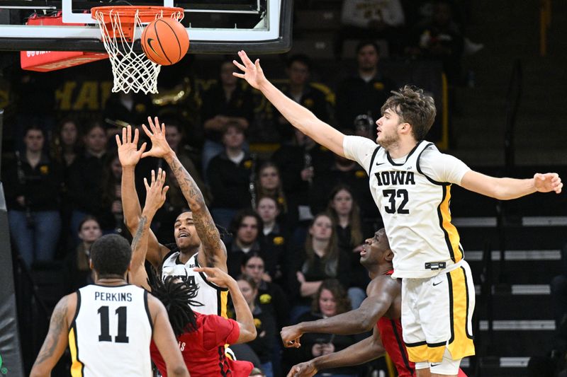 Jan 6, 2024; Iowa City, Iowa, USA; Iowa Hawkeyes forward Owen Freeman (32) and guard Dasonte Bowen (under basket) and guard Tony Perkins (11) defend the shot of Rutgers Scarlet Knights guard Jamichael Davis (1) during the second half at Carver-Hawkeye Arena. Mandatory Credit: Jeffrey Becker-USA TODAY Sports