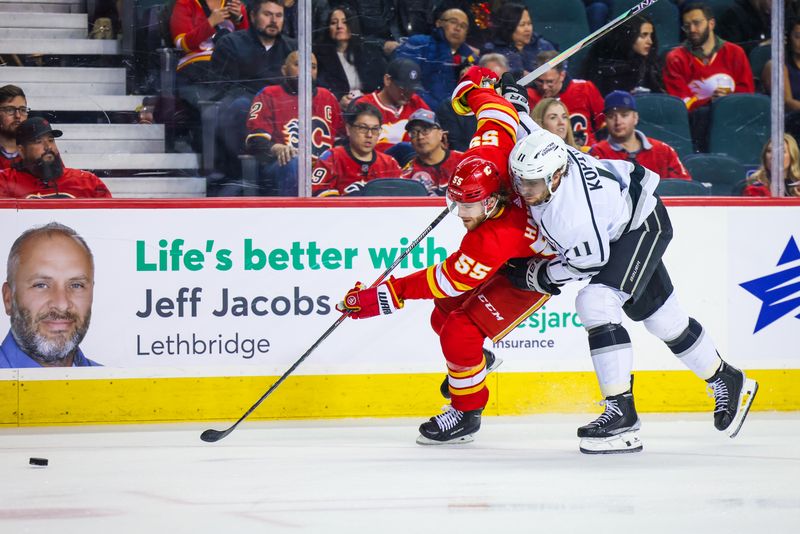 Mar 28, 2023; Calgary, Alberta, CAN; Calgary Flames defenseman Noah Hanifin (55) and Los Angeles Kings center Anze Kopitar (11) battle for the puck during the first period at Scotiabank Saddledome. Mandatory Credit: Sergei Belski-USA TODAY Sports