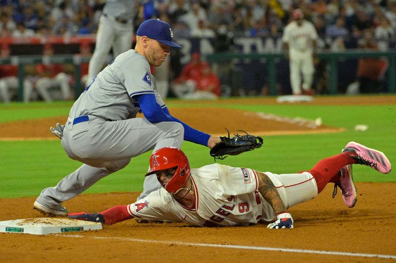 Sep 3, 2024; Anaheim, California, USA;  Los Angeles Angels shortstop Zach Neto (9) beats the throw to Los Angeles Dodgers baseman Freddie Freeman (5) in the fifth inning at Angel Stadium. Mandatory Credit: Jayne Kamin-Oncea-Imagn Images