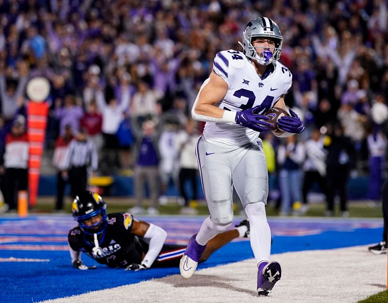 Nov 18, 2023; Lawrence, Kansas, USA; Kansas State Wildcats tight end Ben Sinnott (34) catches a touchdown pass against Kansas Jayhawks safety Marvin Grant (4) during the first half at David Booth Kansas Memorial Stadium. Mandatory Credit: Jay Biggerstaff-USA TODAY Sports