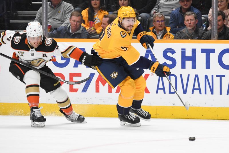 Jan 9, 2024; Nashville, Tennessee, USA; Nashville Predators left wing Filip Forsberg (9) handles the puck past Anaheim Ducks defenseman Cam Fowler (4) during the first period at Bridgestone Arena. Mandatory Credit: Christopher Hanewinckel-USA TODAY Sports