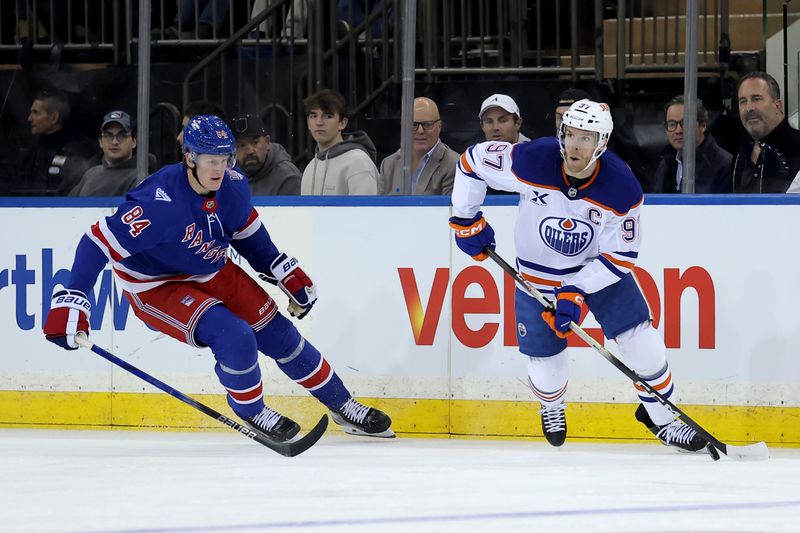 Oct 14, 2025; New York, New York, USA; Edmonton Oilers center Connor McDavid (97) controls the puck against New York Rangers center Adam Edstrom (84) during the first period at Madison Square Garden. Mandatory Credit: Brad Penner-Imagn Images