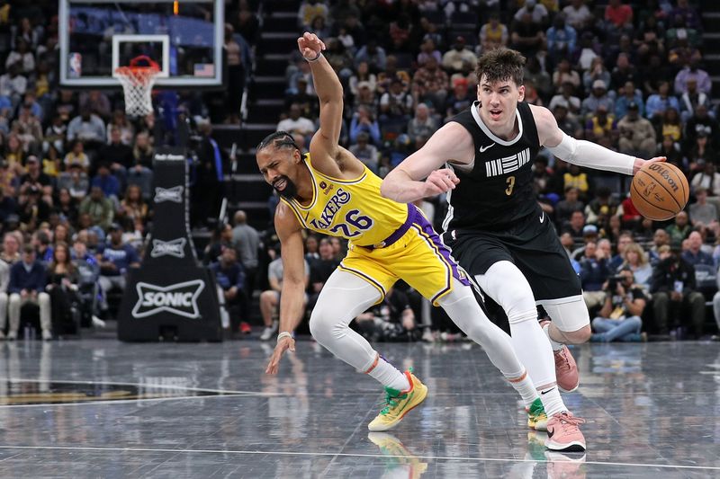 MEMPHIS, TENNESSEE - APRIL 12: Jake LaRavia #3 of the Memphis Grizzlies handles the ball against Spencer Dinwiddie #26 of the Los Angeles Lakers during the second half at FedExForum on April 12, 2024 in Memphis, Tennessee. NOTE TO USER: User expressly acknowledges and agrees that, by downloading and or using this photograph, User is consenting to the terms and conditions of the Getty Images License Agreement. (Photo by Justin Ford/Getty Images)