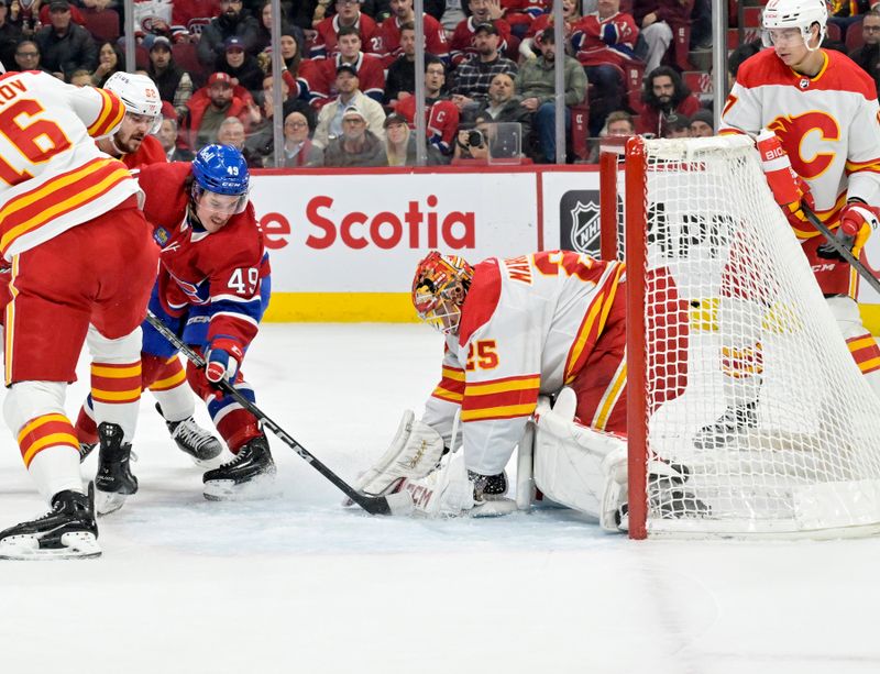 Nov 14, 2023; Montreal, Quebec, CAN; Calgary Flames goalie Jacob Markstrom (25) stops Montreal Canadiens forward Rafael Harvey-Pinard (49) during the first period at the Bell Centre. Mandatory Credit: Eric Bolte-USA TODAY Sports