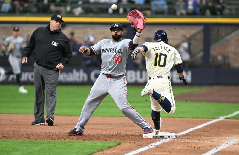 Apr 3, 2024; Milwaukee, Wisconsin, USA; Milwaukee Brewers center fielder Sal Frelick (10) beats a throw to Minnesota Twins first baseman Carlos Santana (30) in the first inning at American Family Field. Mandatory Credit: Michael McLoone-USA TODAY Sports