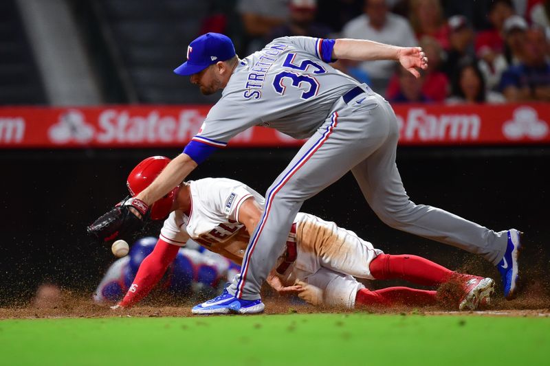 Sep 26, 2023; Anaheim, California, USA; Los Angeles Angels left fielder Randal Grichuk (15) scores a run as Texas Rangers relief pitcher Chris Stratton (35) misses the throw during the fifth inning at Angel Stadium. Mandatory Credit: Gary A. Vasquez-USA TODAY Sports