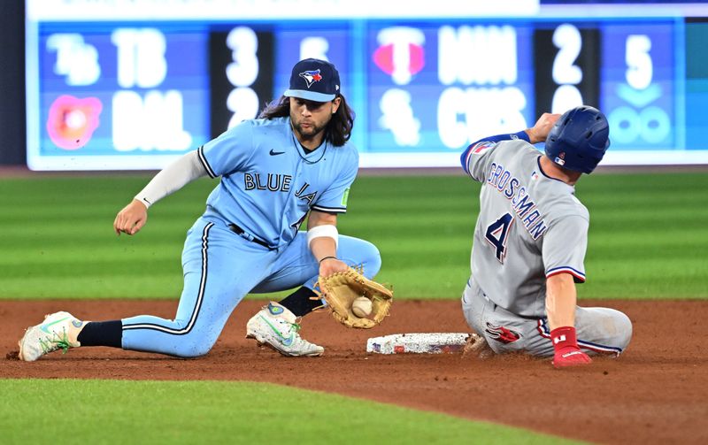 Sep 14, 2023; Toronto, Ontario, CAN;   Texas Rangers right fielder Robbie Grossman (4) steals second base as Toronto Blue Jays shortstop Bo Bichette (11) catches the ball in the fifth inning at Rogers Centre. Mandatory Credit: Dan Hamilton-USA TODAY Sports