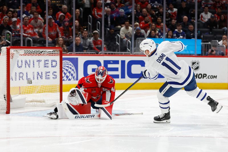 Nov 13, 2024; Washington, District of Columbia, USA; Washington Capitals goaltender Logan Thompson (48) makes a save on Toronto Maple Leafs center Max Domi (11) in the second period at Capital One Arena. Mandatory Credit: Geoff Burke-Imagn Images