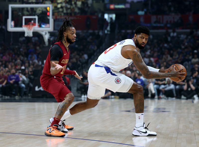 LOS ANGELES, CALIFORNIA - APRIL 07: Paul George #13 of the LA Clippers keeps the ball from Darius Garland #10 of the Cleveland Cavaliers during the first half at Crypto.com Arena on April 07, 2024 in Los Angeles, California. User is consenting to the terms and conditions of the Getty Images License Agreement. (Photo by Harry How/Getty Images)