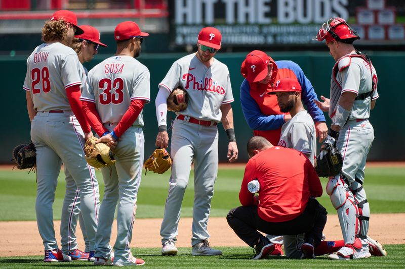 Jun 17, 2023; Oakland, California, USA; Philadelphia Phillies training staff tends to pitcher Cristopher Sanchez (61) after being struck in the pitching hand by a batted ball against the Oakland Athletics during the fourth inning at Oakland-Alameda County Coliseum. Mandatory Credit: Robert Edwards-USA TODAY Sports