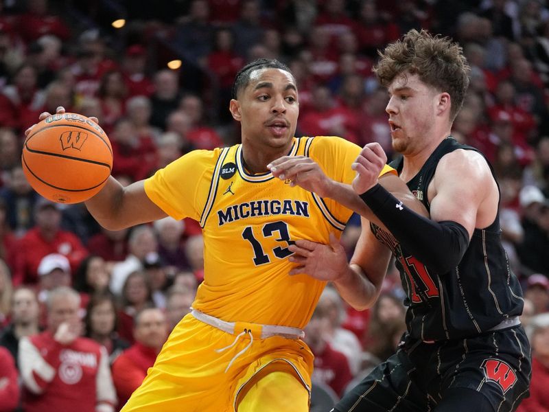 Feb 14, 2023; Madison, Wisconsin, USA;  Michigan Wolverines guard Jett Howard (13) drives to the basket under coverage by Wisconsin Badgers guard Max Klesmit (11) during the first half at the Kohl Center. Mandatory Credit: Kayla Wolf-USA TODAY Sports