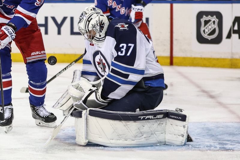 Nov 12, 2024; New York, New York, USA;  Winnipeg Jets goaltender Connor Hellebuyck (37) makes a save on a shot on goal attempt in the second period against the New York Rangers at Madison Square Garden. Mandatory Credit: Wendell Cruz-Imagn Images