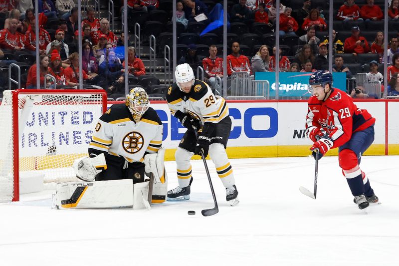 Oct 5, 2024; Washington, District of Columbia, USA; Boston Bruins defenseman Parker Wotherspoon (29) clears the puck from Washington Capitals center Hendrix Lapierre (29) in front of Bruins goaltender Brandon Bussi (30) in the first period at Capital One Arena. Mandatory Credit: Geoff Burke-Imagn Images