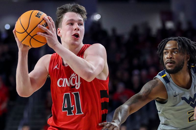 Mar 9, 2024; Cincinnati, Ohio, USA; Cincinnati Bearcats guard Simas Lukosius (41) drives to the basket against West Virginia Mountaineers guard Kobe Johnson (2) in the first half at Fifth Third Arena. Mandatory Credit: Katie Stratman-USA TODAY Sports