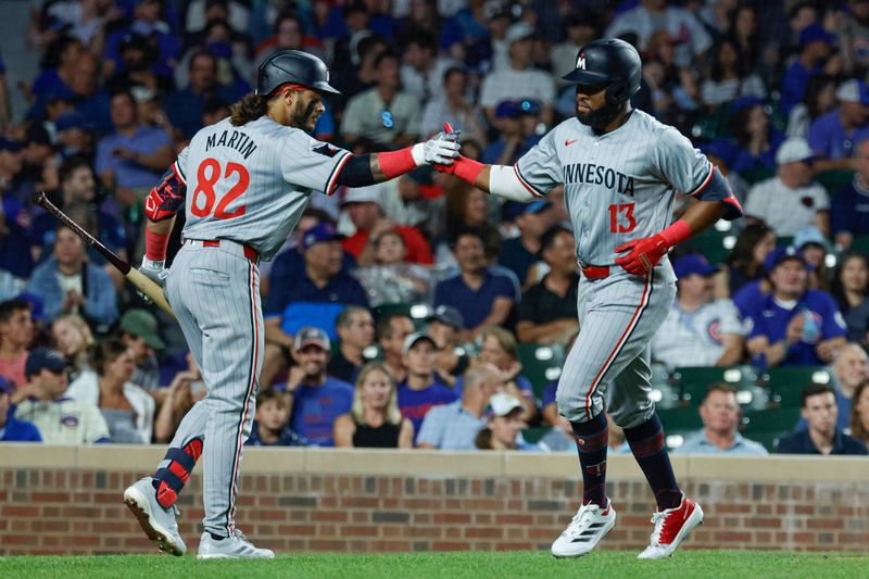 Aug 5, 2024; Chicago, Illinois, USA; Minnesota Twins outfielder Manuel Margot (13) celebrates with outfielder Austin Martin (82) after hitting a solo home run against the Chicago Cubs during the fifth inning at Wrigley Field. Mandatory Credit: Kamil Krzaczynski-USA TODAY Sports