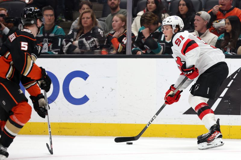 Mar 1, 2024; Anaheim, California, USA; New Jersey Devils center Dawson Mercer (91) controls the puck against Anaheim Ducks defenseman Urho Vaakanainen (5) during the third period at Honda Center. Mandatory Credit: Kiyoshi Mio-USA TODAY Sports