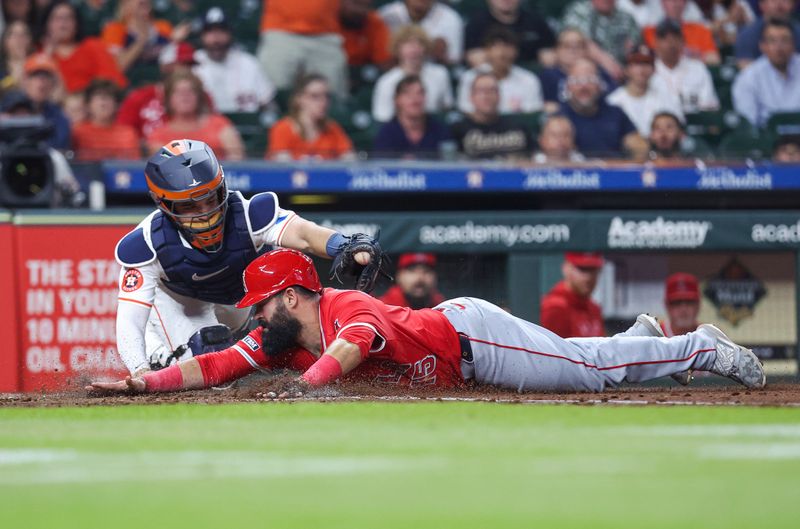 May 21, 2024; Houston, Texas, USA; Los Angeles Angels second baseman Luis Guillorme (15) slides safely under the tag of Houston Astros catcher Yainer Diaz (21) to score a run during the fourth inning at Minute Maid Park. Mandatory Credit: Troy Taormina-USA TODAY Sports