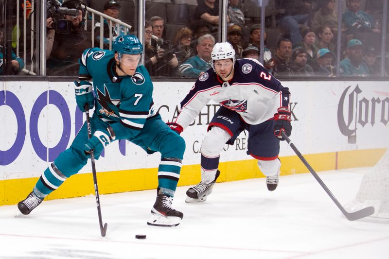 Mar 14, 2023; San Jose, California, USA; Columbus Blue Jackets defenseman Andrew Peeke (2) and San Jose Sharks center Nico Sturm (7) pursue the puck during the second period at SAP Center at San Jose. Mandatory Credit: D. Ross Cameron-USA TODAY Sports