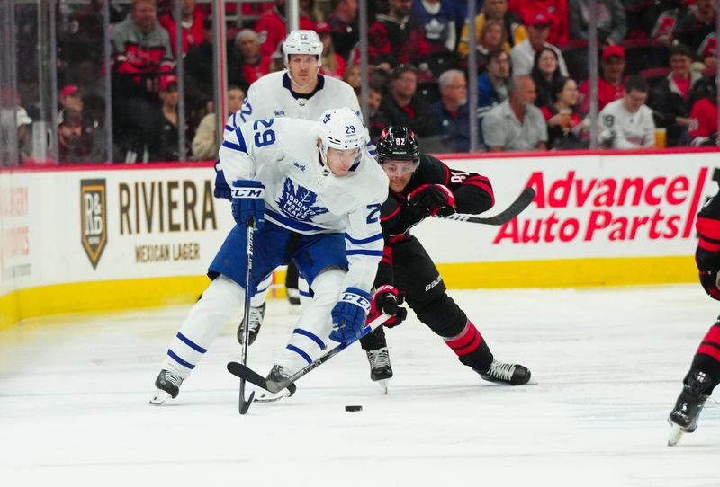 Mar 24, 2024; Raleigh, North Carolina, USA;  Toronto Maple Leafs right wing Pontus Holmberg (29) controls the puck past Carolina Hurricanes center Evgeny Kuznetsov (92) during the second period at PNC Arena. Mandatory Credit: James Guillory-USA TODAY Sports