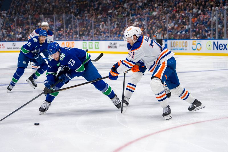 May 8, 2024; Vancouver, British Columbia, CAN; Edmonton Oilers forward Ryan McLeod (71) stick checks Vancouver Canucks forward Elias Lindholm (23) during the third period in game one of the second round of the 2024 Stanley Cup Playoffs at Rogers Arena. Mandatory Credit: Bob Frid-USA TODAY Sports