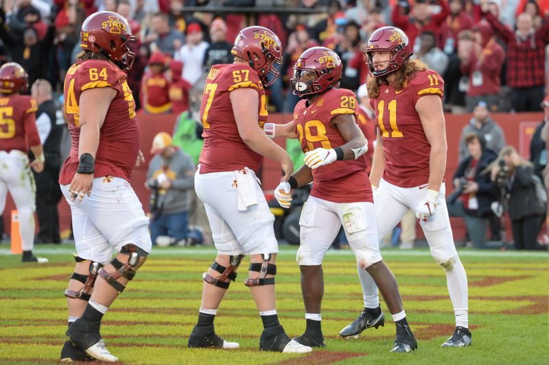 Oct 23, 2021; Ames, Iowa, USA;  Iowa State Cyclones running back Breece Hall (28) celebrates with offensive lineman Derek Schweiger (64) and offensive lineman Colin Newell (57) and tight end Chase Allen (11) after scoring the winning touchdown against the Oklahoma State Cowboys in the second half at Jack Trice Stadium. Mandatory Credit: Steven Branscombe-USA TODAY Sports