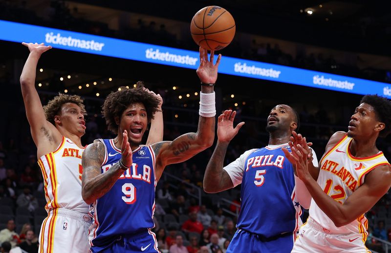 ATLANTA, GEORGIA - OCTOBER 14:  Kelly Oubre Jr. #9 of the Philadelphia 76ers passes the ball as he drives into Dyson Daniels #5 of the Atlanta Hawks during the first quarter at State Farm Arena on October 14, 2024 in Atlanta, Georgia.  NOTE TO USER: User expressly acknowledges and agrees that, by downloading and/or using this photograph, user is consenting to the terms and conditions of the Getty Images License Agreement.  (Photo by Kevin C. Cox/Getty Images)