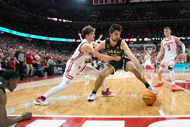 Mar 2, 2023; Madison, Wisconsin, USA;  Wisconsin Badgers guard Max Klesmit (11) fouls Purdue Boilermakers guard Ethan Morton (25) during the second half at the Kohl Center. Mandatory Credit: Kayla Wolf-USA TODAY Sports