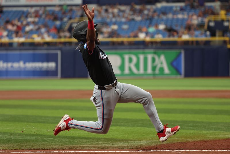 Jul 31, 2024; St. Petersburg, Florida, USA;  Miami Marlins shortstop Vidal Brujan (17) slides into home plate to score a run against the Tampa Bay Rays during the third inning at Tropicana Field. Mandatory Credit: Kim Klement Neitzel-USA TODAY Sports