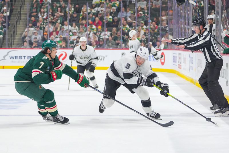 Nov 5, 2024; Saint Paul, Minnesota, USA; Los Angeles Kings right wing Adrian Kempe (9) skates with the puck against the Minnesota Wild defenseman Brock Faber (7) in the first period at Xcel Energy Center. Mandatory Credit: Brad Rempel-Imagn Images