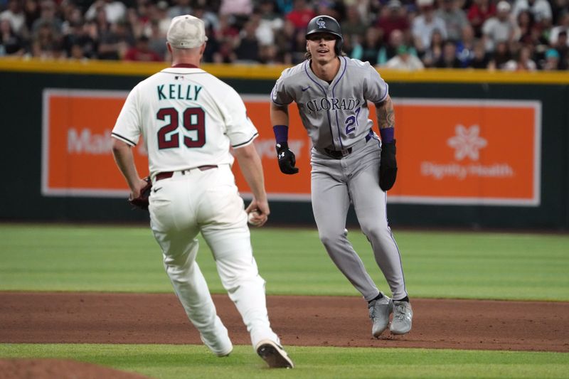May 18, 2025; Phoenix, Arizona, USA; Colorado Rockies outfielder Jordan Beck (27) gets in a run down with Arizona Diamondbacks pitcher Merrill Kelly (29) in the sixth inning at Chase Field. Mandatory Credit: Rick Scuteri-Imagn Images