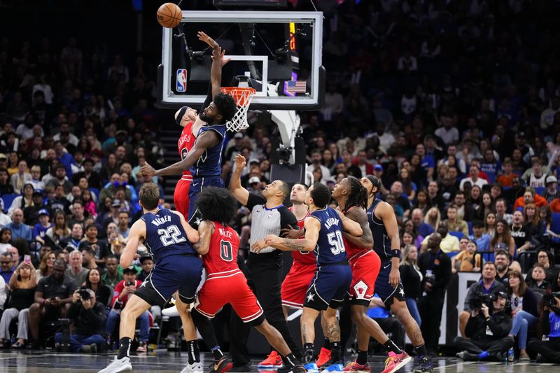 ORLANDO, FLORIDA - FEBRUARY 10: Alex Caruso #6 of the Chicago Bulls and Jonathan Isaac #1 of the Orlando Magic compete for a jump ball during the fourth quarter at Kia Center on February 10, 2024 in Orlando, Florida. NOTE TO USER: User expressly acknowledges and agrees that, by downloading and or using this photograph, user is consenting to the terms and conditions of the Getty Images License Agreement. (Photo by Rich Storry/Getty Images)