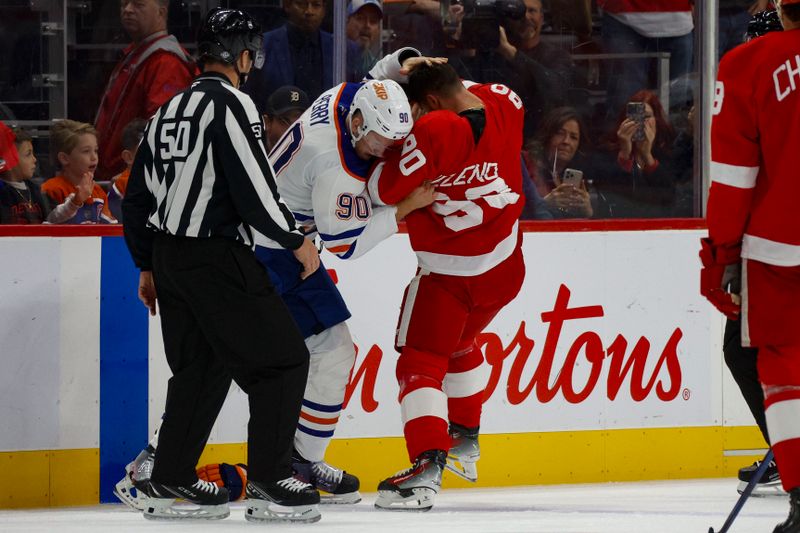 Oct 27, 2024; Detroit, Michigan, USA; Detroit Red Wings center Joe Veleno (90) fights with Edmonton Oilers right wing Corey Perry (90) during the first period of the game at Little Caesars Arena. Mandatory Credit: Brian Bradshaw Sevald-Imagn Images