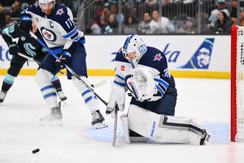 Mar 8, 2024; Seattle, Washington, USA; Winnipeg Jets goaltender Laurent Brossoit (39) blocks a goal shot against the Seattle Kraken during the second period at Climate Pledge Arena. Mandatory Credit: Steven Bisig-USA TODAY Sports