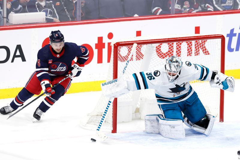 Feb 14, 2024; Winnipeg, Manitoba, CAN; Winnipeg Jets defenseman Neal Pionk (4) looks for a rebound after San Jose Sharks goaltender Kaapo Kahkonen (36) blocks a shot in the third period at Canada Life Centre. Mandatory Credit: James Carey Lauder-USA TODAY Sports