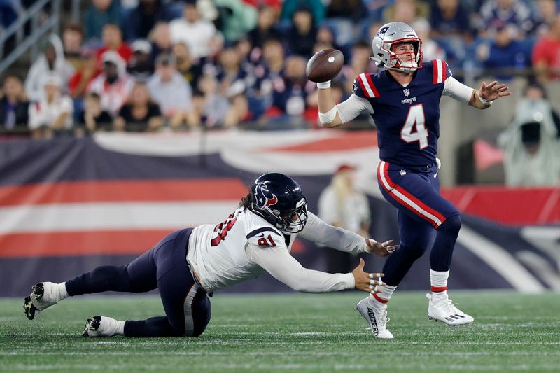 Houston Texans defensive tackle Roy Lopez, left, reaches for New England Patriots quarterback Bailey Zappe (4) during the first half of an NFL preseason football game Thursday, Aug. 10, 2023, in Foxborough, Mass. (AP Photo/Michael Dwyer)