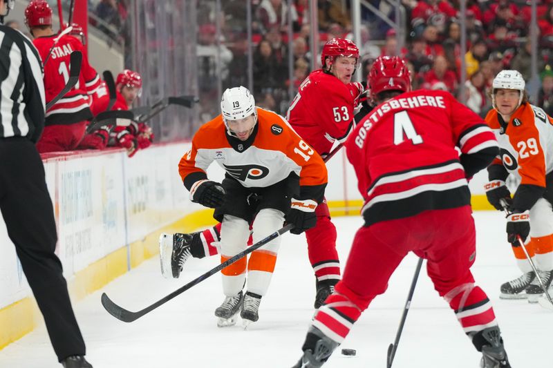Dec 14, 2025; Raleigh, North Carolina, USA; Carolina Hurricanes right wing Jackson Blake (53) avoids a check by Philadelphia Flyers right wing Garnet Hathaway (19) during the second period at Lenovo Center. Mandatory Credit: James Guillory-Imagn Images