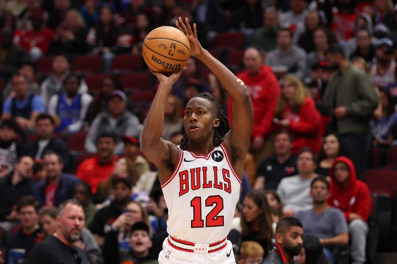 CHICAGO, ILLINOIS - MARCH 11: Ayo Dosunmu #12 of the Chicago Bulls shoots a three pointer against the Dallas Mavericks during the second half at the United Center on March 11, 2024 in Chicago, Illinois. NOTE TO USER: User expressly acknowledges and agrees that, by downloading and or using this photograph, User is consenting to the terms and conditions of the Getty Images License Agreement.  (Photo by Michael Reaves/Getty Images)