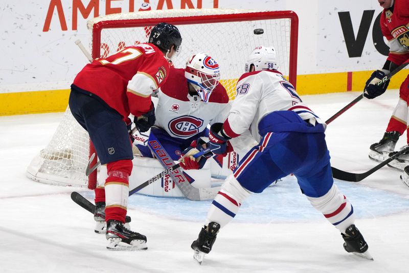 Dec 30, 2023; Sunrise, Florida, USA;  Florida Panthers center Eetu Luostarinen (27) lifts a shot over Montreal Canadiens goaltender Jake Allen (34) for a goal during the third period at Amerant Bank Arena. Mandatory Credit: Jim Rassol-USA TODAY Sports