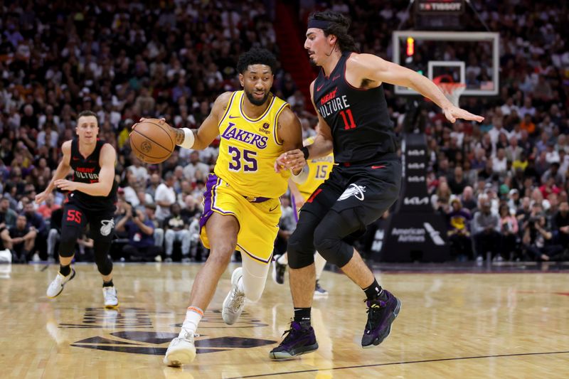 MIAMI, FLORIDA - NOVEMBER 06: Christian Wood #35 of the Los Angeles Lakers drives against Jaime Jaquez Jr. #11 of the Miami Heat during the second quarter of the games at Kaseya Center on November 06, 2023 in Miami, Florida. NOTE TO USER: User expressly acknowledges and agrees that, by downloading and or using this photograph, User is consenting to the terms and conditions of the Getty Images License Agreement. (Photo by Megan Briggs/Getty Images)