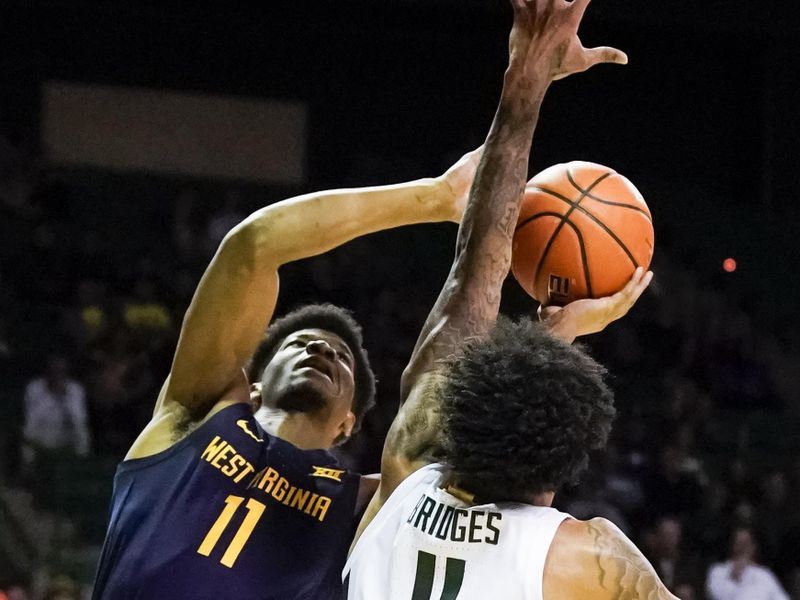 Feb 13, 2023; Waco, Texas, USA; West Virginia Mountaineers forward Mohamed Wague (11) shoots over Baylor Bears forward Jalen Bridges (11) during the first half at Ferrell Center. Mandatory Credit: Raymond Carlin III-USA TODAY Sports